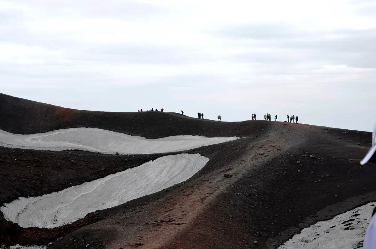 Hikers on a snowy ridge on Etna